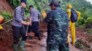 Petugas gabungan membersihkan material longsor yang menutup akses jalan di Desa Pasir Panjang Salem. /Ist